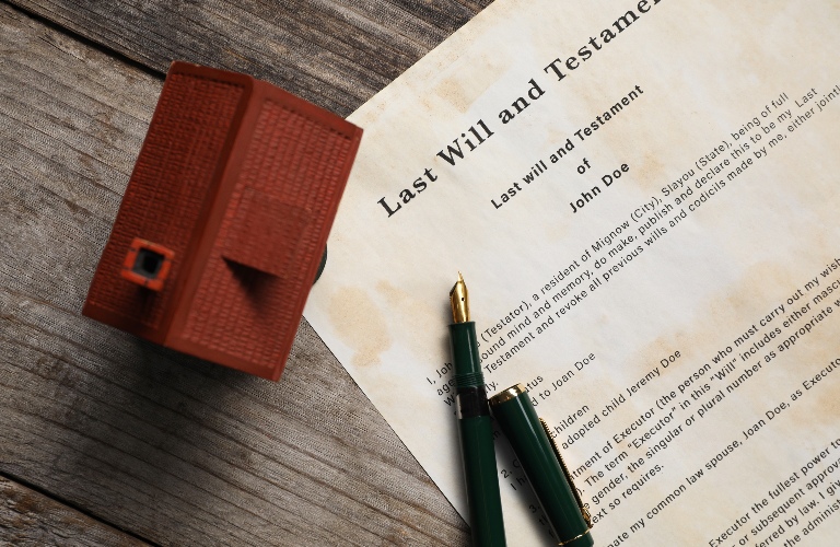 Last Will and Testament with fountain pen and house model