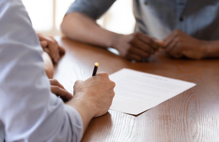 man is signing documents